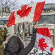 OTTAWA, ON - JANUARY 30: A woman waves a flag and cheers on truckers in protest of COVID-19 vaccine mandates on January 30, 2022 in Ottawa, Canada. Thousands turned up over the weekend to rally in support of truckers using their vehicles to block access to Parliament Hill, most of the downtown area Ottawa, and the Alberta border in hopes of pressuring the government to roll back COVID-19 public health regulations.